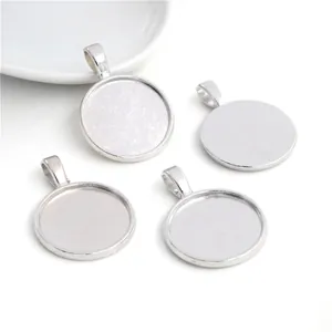 Nahaufnahme von vier polierten silbernen 20mm Legierung Anhängerbasen für DIY Schmuck
