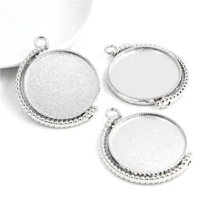 Macro-opname van zilveren ronde hangerbakjes met kralenrand voor DIY-sieraden maken