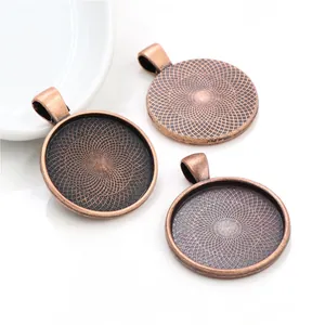 Detailed view of 30mm round alloy pendant trays with vintage radial texture and hangers