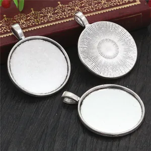 Retro 30mm alloy pendant base trays for jewelry DIY on dark wood surface with box