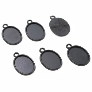 Macro detail of oval alloy pendant base with matte black finish and textured back