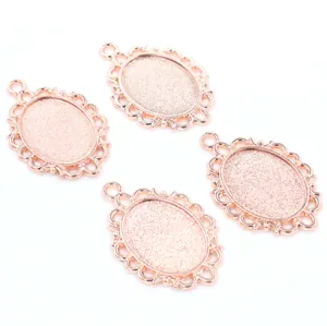 Detail view of four rose gold oval alloy pendants with vintage hollow lace borders for DIY