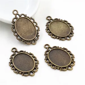 Set of four 13x18mm oval alloy pendant trays with vintage hollow lace design on white background
