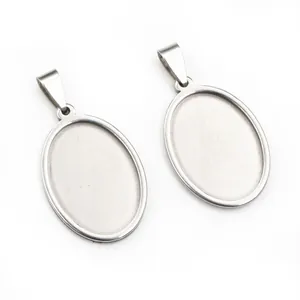 Macro detail of oval stainless steel pendant trays with hanging loops for jewelry making