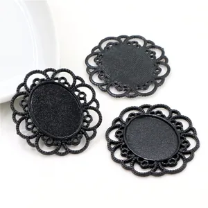 Detail view of black vintage lace alloy pendant bases with intricate hollow floral texture