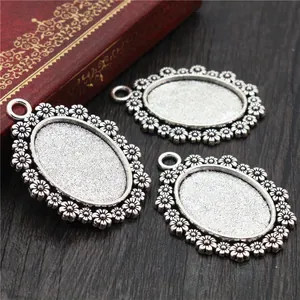 Set of three antique silver oval alloy pendant bases with embossed floral daisy edges