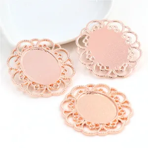 Three rose gold oval filigree pendant trays for DIY jewelry making on white background