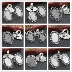 Nine vintage silver oval alloy ring bases with adjustable bands and antique floral borders