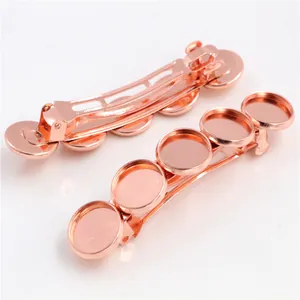 Detail van twee roségouden veerhaarklemmen met vijf ronde DIY-trays voor sieraden