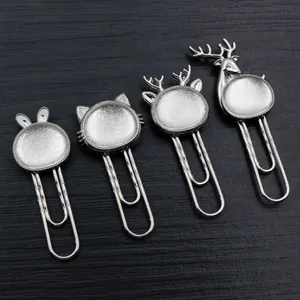 Set of four silver metal animal paperclips with DIY gem trays on a dark wood surface