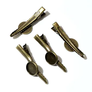 Set of four vintage bronze DIY hair clips with flat round tray bases for crafting