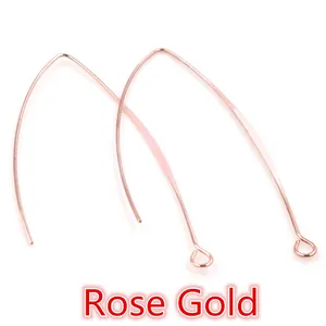 Detailed macro view of V-shaped rose gold earring hooks with smooth metallic finish