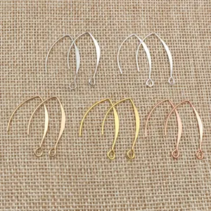 DIY V-shaped copper earring hooks in five metallic finishes on linen background