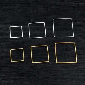 Quadratische hohle Ohrring-Anhänger aus Kupfer in Gold und Silber auf Holzuntergrund