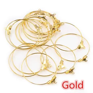 Close-up of gold-plated metal wine glass rings and earring hoops with DIY loop fasteners