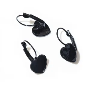 Detail of three black heart-shaped lever-back earrings with a glossy lacquer finish