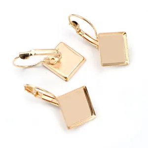 Close-up of golden lever-back earrings with square bezel settings for DIY jewelry making