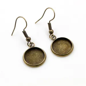 Close-up of antique bronze earring hooks with circular bezel trays for DIY jewelry making