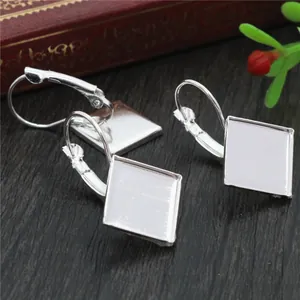 Square silver leverback earring hooks for DIY jewelry making on wooden background