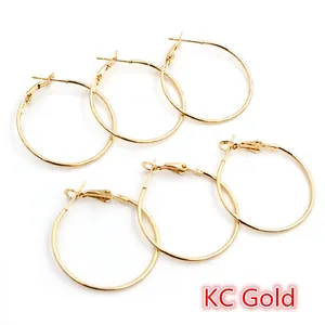 Détail des boucles d'oreilles créoles rondes plaquées or KC au design minimaliste