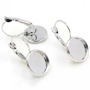 Close-up of three silver lever-back earring hooks with round bezel cups for DIY jewelry
