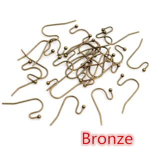 Detailed view of bronze S-shaped earring hooks with ball ends for DIY jewelry making