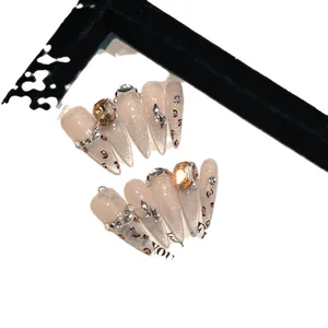Handmade almond press-on nails with pink cat-eye base, leopard pattern, and luxury crystals