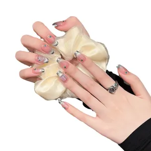 Faux ongles œil de chat style français avec strass bleus et pointes argentées sur ongles longs