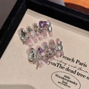 Handmade press-on nails with purple cat-eye design, rhinestones, and butterfly charms