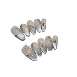 Gray-blue cat eye press-on nails with sparkling rhinestones and pearls on almond shape