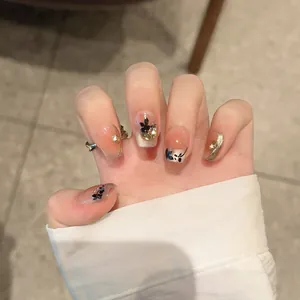 Handmade press-on nails with maple leaf design, peach gradient, and gold foil accents