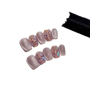 Purple cat-eye press-on nails with glitter shells and gold leaf accents in coffin shape