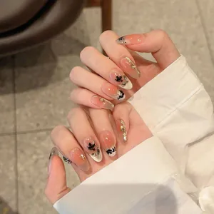 Press-on nails with maple leaf art and gold metallic lines on pink gradient base