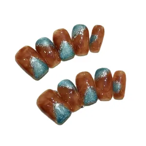 Amber marble press-on nails with blue-green glitter accents in minimalist luxury style