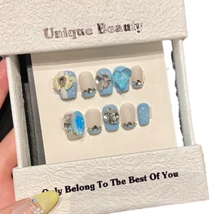 Handmade light blue press-on nails with 3D hearts, bows, and sparkling rhinestones