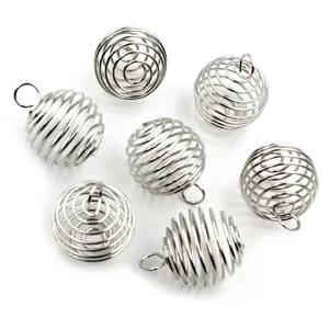 Macro-opname van zeven zilveren holle spiraalvormige kooihangers voor DIY-sieraden