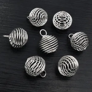Macro-opname van zeven zilveren spiraalkooi hangers voor DIY-sieraden en kralen
