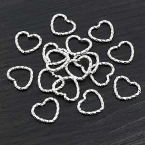 Macro view of silver heart-shaped textured jump rings for DIY jewelry making