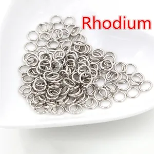 Macro di anellini aperti rodiati in un piatto a cuore per creazione di gioielli