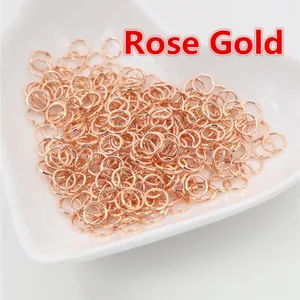 Dettaglio di anellini aperti placcati in oro rosa per gioielli fai-da-te in un piatto