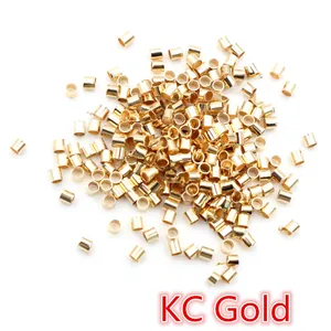 Macro view of tiny KC gold plated crimp bead tubes for DIY jewelry making and bead fixing
