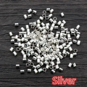 Macro shot of silver metal crimp beads for DIY jewelry making on dark wood texture