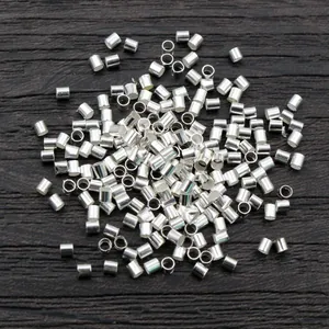 500pcs bulk silver-plated crimp beads for jewelry making on dark wood background