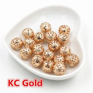Detailed macro view of hollow gold metal beads for jewelry making in a heart-shaped tray
