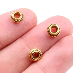 Vista macro de cuentas espaciadoras doradas de 5mm para creación de joyas a mano
