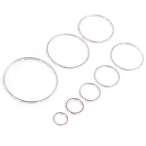Set di sette anelli in rame placcato argento di varie dimensioni su sfondo bianco puro