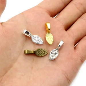 Leaf-shaped shovel alloy pendants in gold silver and bronze finish on palm
