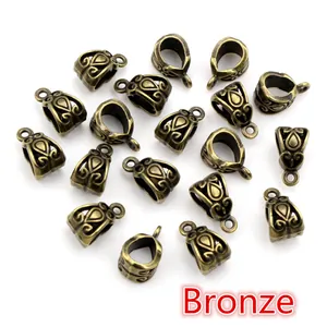 Macro shot of bronze alloy bail beads with hollow scroll patterns for DIY jewelry