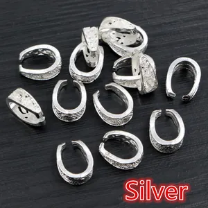 Detailed view of silver alloy bail connectors with baroque patterns on wood background