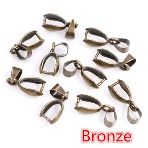 Detailed view of vintage bronze pendant bails and pinch clasps for jewelry making